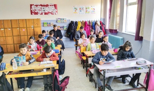 Öğrenciler kurum amirleriyle kitap okuyor