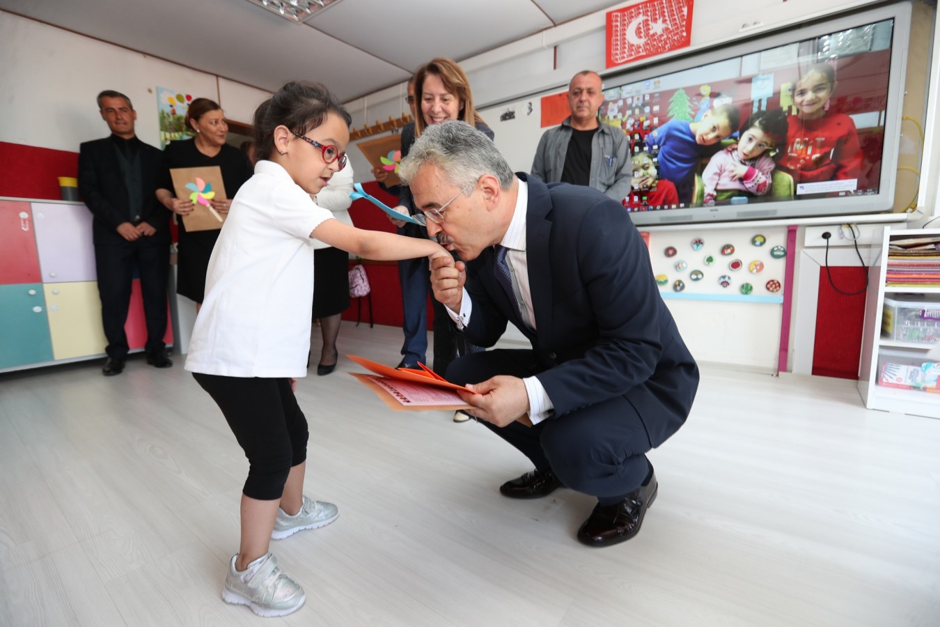 Vali işitme engelli öğrencinin elini öperek karnesini verdi