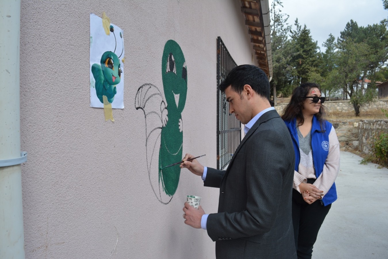 Öğrencilerle okulun duvarına resim yaptı;