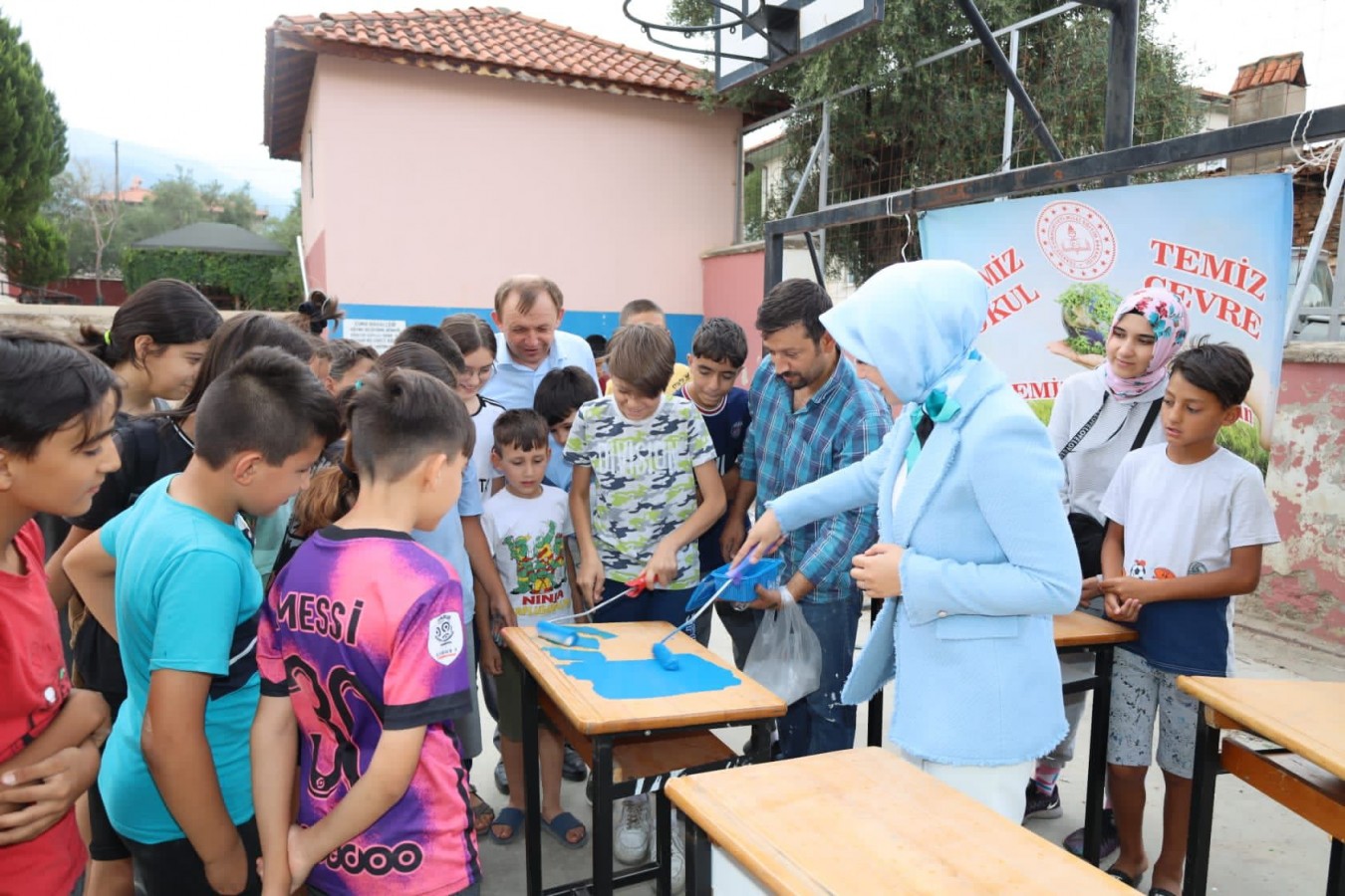 Birlikte okulun sıralarını boyadılar;